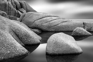 Black and white nature art of granite stones on water in Nova Scotia by iCanvas artist Jeff Friesen