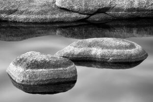 Black and white nature photography of stones atop water by iCanvas artist Jeff Friesen