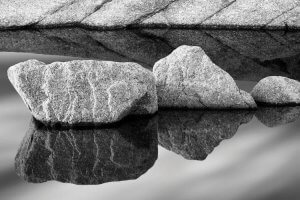 Black and white nature art of three stones reflecting in water by iCanvas artist Jeff Friesen