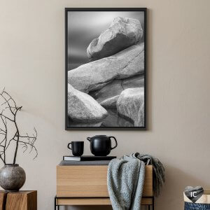 Framed black and white photo of stacked stones by iCanvas artist Jeff Friesen mounted above a table and tea set