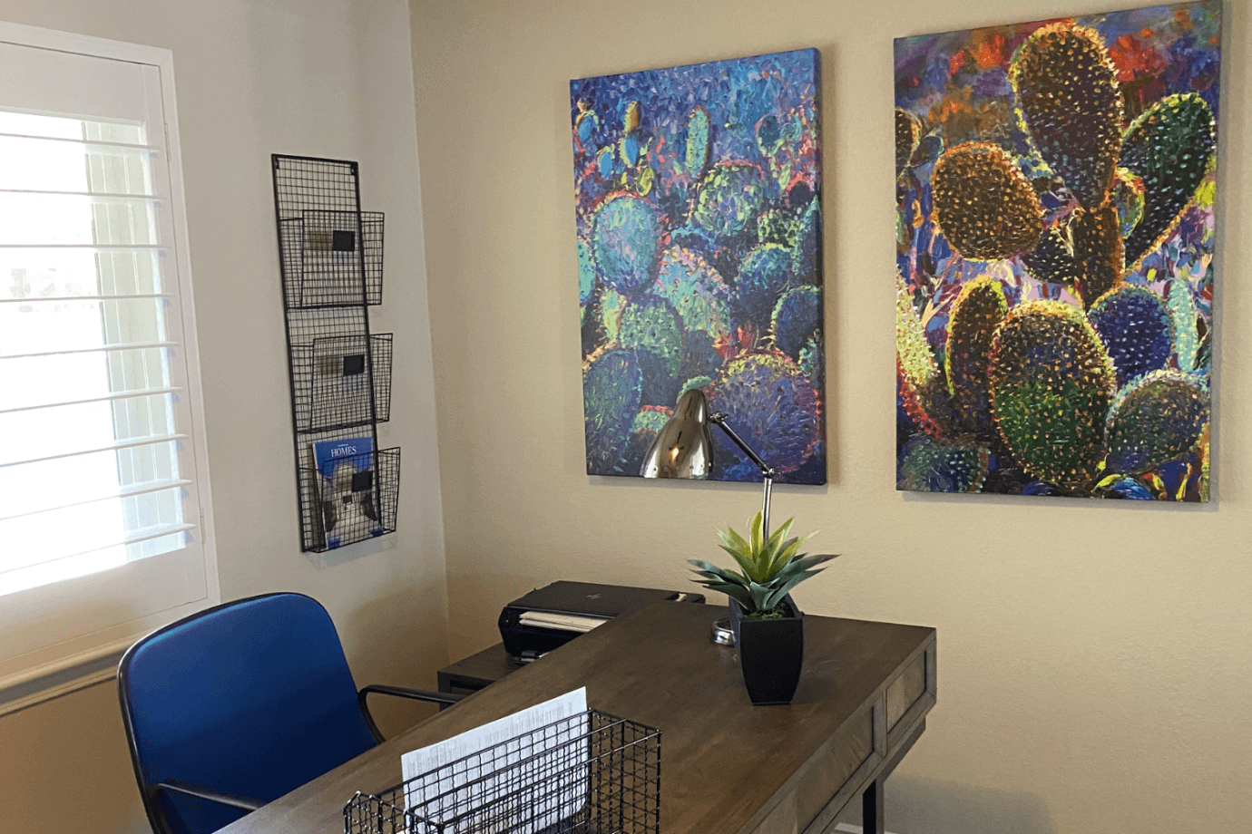 cactus prints hanging on wall near desk