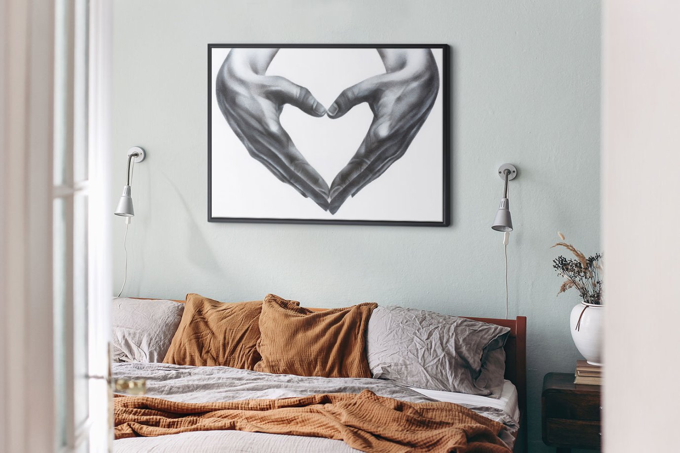 black and white heart hands artwork above bed