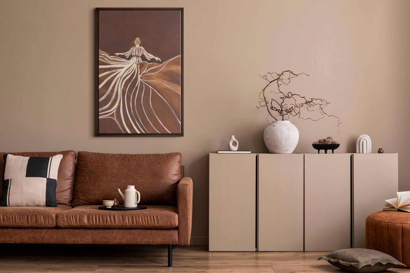 abstract brown painting of woman in dress above couch